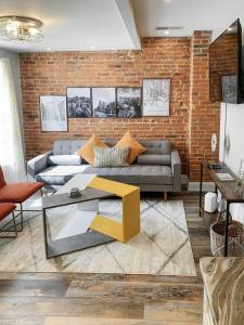 巴尔的摩Cozy Modern Apt in the Heart of Fells Point!的带沙发和砖墙的客厅