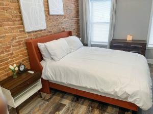 巴尔的摩Cozy Modern Apt in the Heart of Fells Point!的一间卧室设有一张床和砖墙