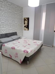 布林迪西Casa vacanza Sofy的一间卧室配有一张带粉色和白色毯子的床