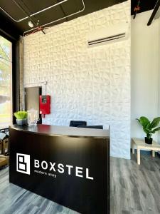 埃尔帕索Boxstel - Modern Stay Hotel Downtown El Paso的墙上有盒子标志的前台