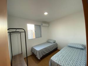 隆德里纳Apartamento com Sacada na Gleba, Novo e equipado的小房间设有两张床和窗户