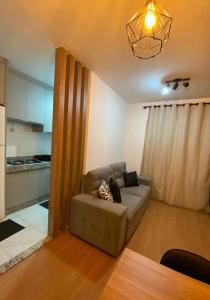 隆德里纳Apartamento com Sacada na Gleba, Novo e equipado的带沙发的客厅和厨房