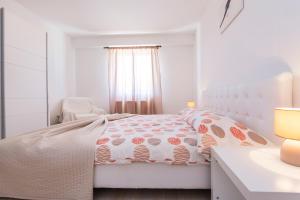 布泽特Apartmani Xenia & Desiderio的白色卧室配有床和椅子