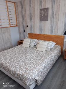 RamonchampMonts et Rêves的一间卧室配有一张带木制床头板和枕头的床。