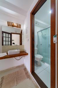 普拉亚多Praia do Forte Suites的一间带水槽和玻璃淋浴的浴室