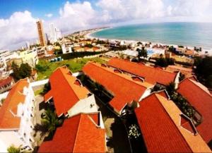 纳塔尔Yacht Village Natal Prime的享有海滩、红色建筑和大海的景色