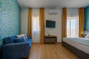 埃尔哥茨拉Marina Suites & apartments - Self catering - by Tritoni hotels的一间卧室配有蓝色的床和蓝色椅子
