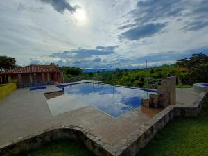 金巴亚Hotel Campestre Los Mangos的一座带房子的庭院内的游泳池