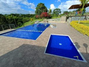 金巴亚Hotel Campestre Los Mangos的后院的游泳池,带有蓝色的游泳池