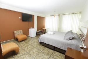 利马帕达玛酒店的配有一张床和一把椅子的酒店客房