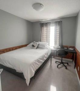科克伦Entire Home Near Calgary, Canmore & Banff Rocky Mountain Gateway的一间卧室配有一张床、一张书桌和一个窗户。