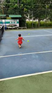 格卢市社Khách sạn Phương Dung的一个小女孩在网球场打网球