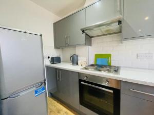 伦敦Lovely 2 bedroom serviced apartment in London的厨房配有不锈钢用具和冰箱
