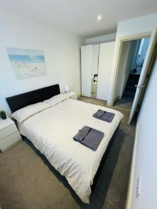 伦敦Lovely 2 bedroom serviced apartment in London的一间卧室配有一张大床和毛巾