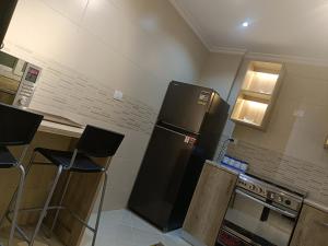 开罗Sheraton ocean 603 - Private apartments的厨房配有黑色冰箱和一些凳子