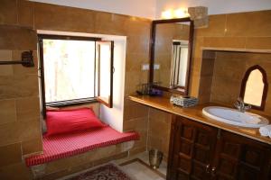 斋沙默尔奇拉芭旺酒店的浴室设有位于水槽旁的红色长凳