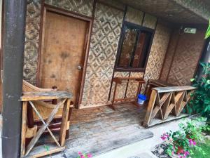 莫阿尔博阿Allba's Homestay的房屋的前门,房子有两把椅子
