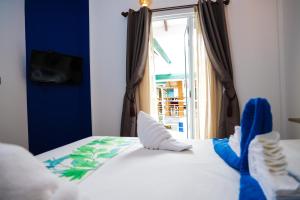 拉斯杜棕榈树旅馆的一间卧室,床上有蓝色鞋
