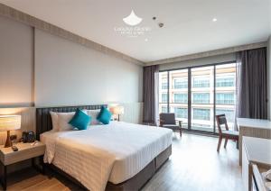 宋卡Laguna Grand Hotel & Spa Songkhla的酒店客房配有一张带蓝色枕头的大床