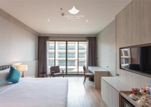 宋卡Laguna Grand Hotel & Spa Songkhla的配有一张床和一张书桌的酒店客房