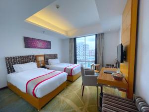 达卡孟加拉金丝雀公园酒店的酒店客房配有两张床和一张书桌
