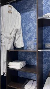 塔什干FRОDО - Cozy as a home for 2-5 persons的衣柜,带毛巾和衬衫的架子