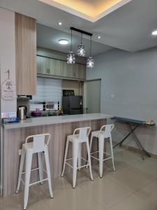 普特拉贾亚3R2B Entire Apartment Air-Conditioned by WNZ Home Putrajaya for Islamic Guests Only的厨房配有白色的凳子和柜台。