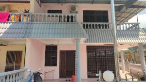 卡庞帕斯班伽克Pangkor Bogar Beach Homestay 邦咯岛民宿的粉红色的房子设有阳台和楼梯