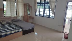 卡庞帕斯班伽克Pangkor Bogar Beach Homestay 邦咯岛民宿的一间卧室设有一张床和两个窗户。
