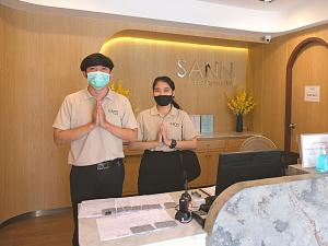 清莱Sann Boutique Hotel的两个戴面具的男子站在一张桌子前