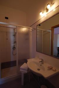 托尔托雷托Hotel Clara的浴室配有盥洗盆和带镜子的淋浴