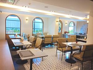 清莱Sann Boutique Hotel的餐厅设有桌椅和窗户。
