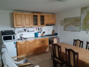 卢奇基Apartmán u Benkov的厨房配有木制橱柜、桌子和水槽。