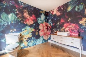 沃明斯特Immaculate 6 Bed House - Unique Cellar Bar- Airbnb的一间带卫生间的浴室和花卉壁纸