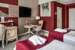 利沃夫Grand Hotel Lviv Casino & Spa的酒店客房设有两张床和一张桌子。