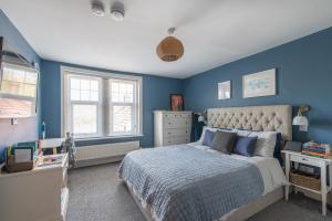 沃明斯特Immaculate 6 Bed House - Unique Cellar Bar- Airbnb的一间拥有蓝色墙壁和一张大床的卧室