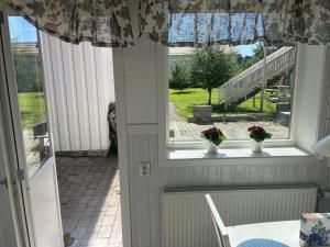 博伦厄Lärkan21 Tvisegatan 24C的一间设有桌子的房间和鲜花窗户