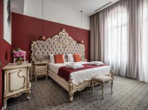 利沃夫Grand Hotel Lviv Casino & Spa的一间卧室设有一张大床和红色的墙壁