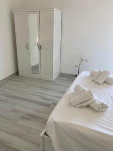 克罗托内KROTONIATI APARTMENT的卧室配有白色床和毛巾