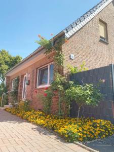 内特塔尔Helle Ferienwohnung in Nettetal bei Venlo的前面有鲜花的砖房