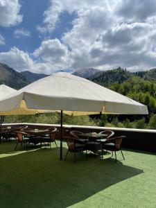 阿拉木图西莫尔度假及SPA酒店的一组桌子和椅子,放在一个大伞下
