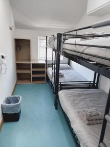 道格拉斯Voyage Hostel - Rooms with Shared Kitchen的客房设有两张双层床,铺有蓝色地板。