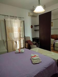 卡坦扎罗Appartamento Due Camere Magna Graecia的一间卧室配有一张紫色床和两条毛巾