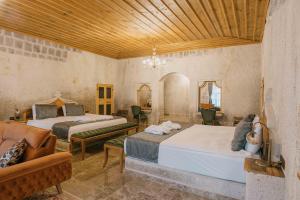 格雷梅Lunar Cappadocia Hotel的一间带两张床和一张沙发的卧室