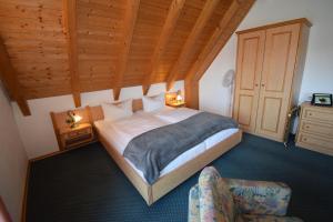 布格哈斯拉赫斯特格沃德豪斯兰德酒店的一间卧室配有一张大床和一把椅子