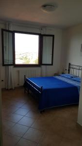 帕拉伊阿A CASA DEL SOLE的一间卧室设有蓝色的床和大窗户