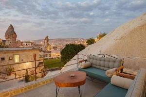 格雷梅Lunar Cappadocia Hotel的阳台设有沙发和桌子,享有美景。