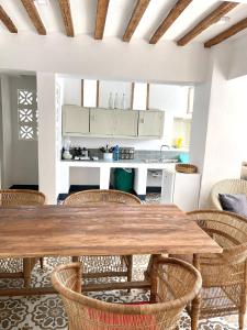马特姆维Zanzibar Tiny Villa at La Villa De Victor的厨房以及带木桌和椅子的用餐室。