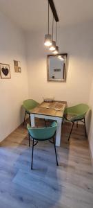 埃森Ferienwohnung Veit的一张桌子和两张绿椅