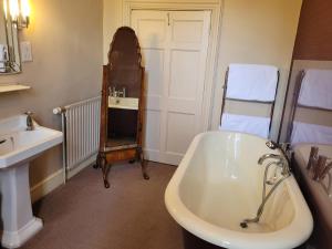 金顿The Old Vicarage的浴室配有盥洗盆和浴缸。
